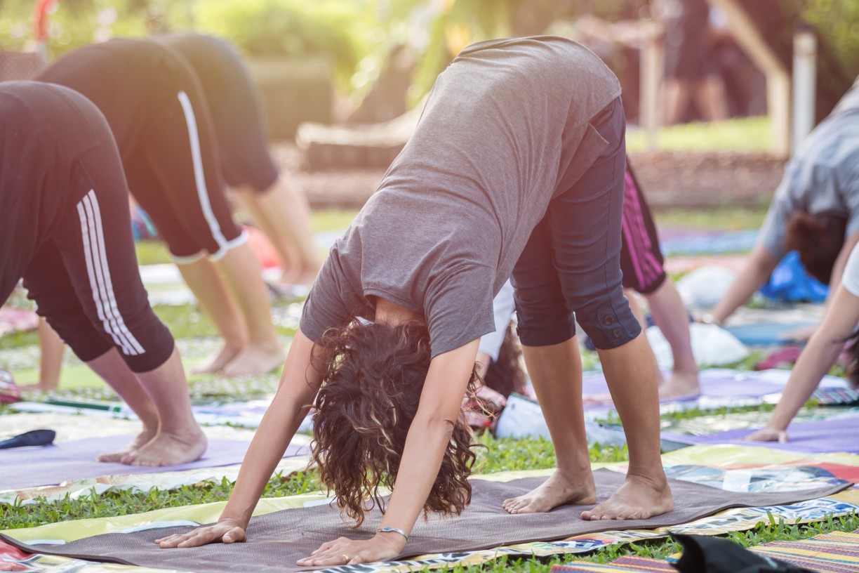 Group doing yoga outdoors at community health and wellness event