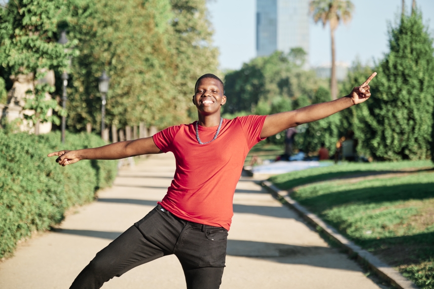 A young man dances down the city sidewalk, rejoicing in his self wellness journey.